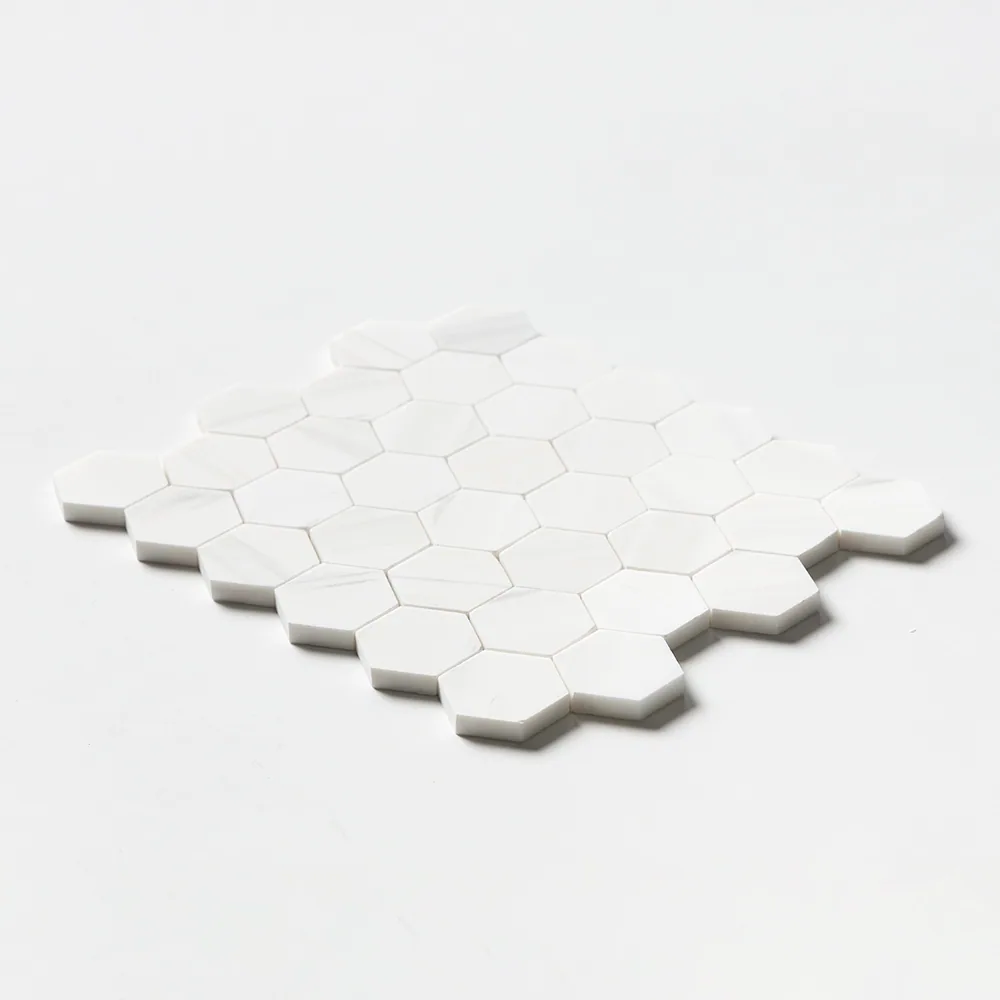 Bianco Dolomiti Classic hexagon mosaic in bright white honed marble, the sheet tilted at a low angle against a white ground.