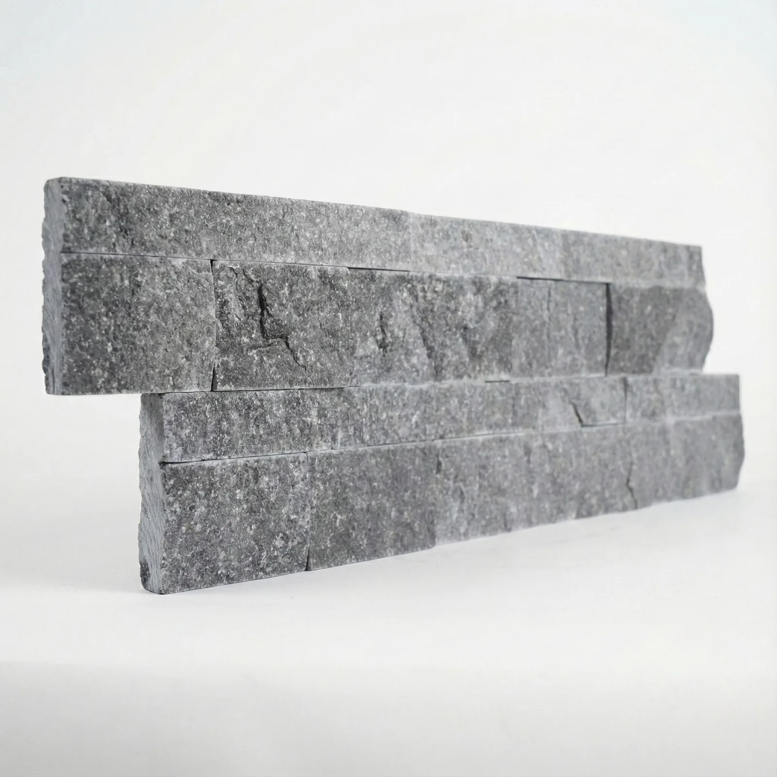 A black marble ledger panel tilted at a low angle, showing the depth of the split face along its length.