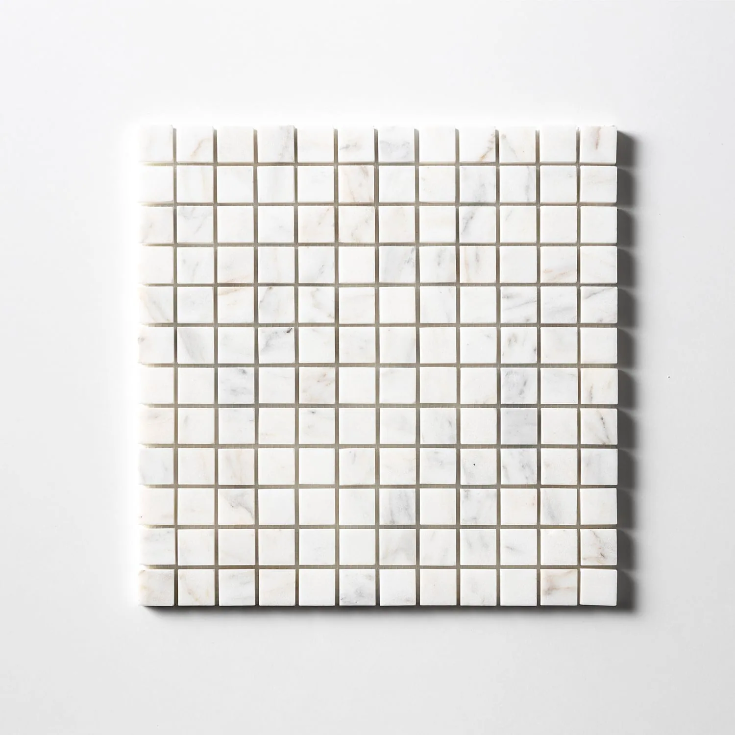 Calacatta Gold mosaic of one-inch squares seen straight on, predominantly white with occasional chips carrying grey and warm gold veining.