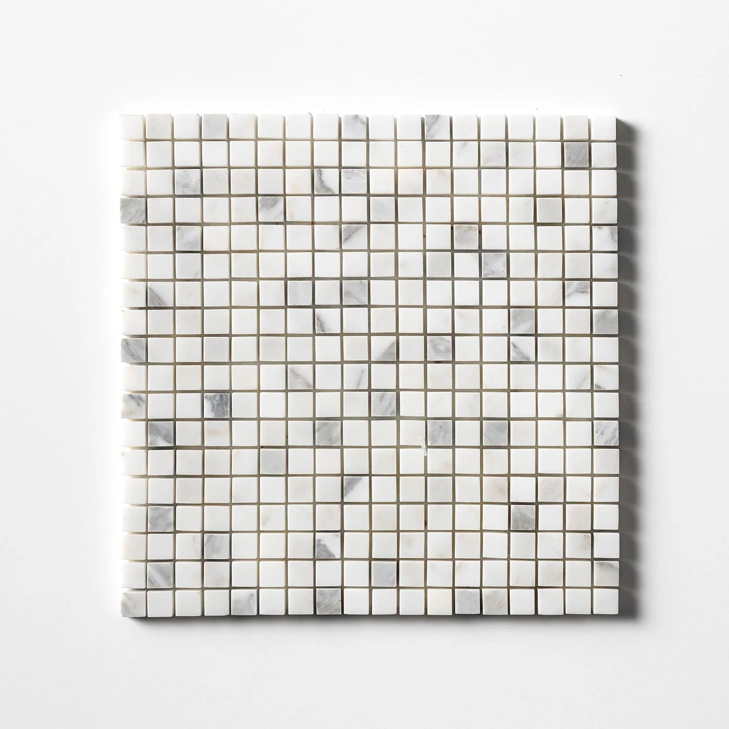 Calacatta Gold marble mosaic sheet of small 5/8 inch squares, mostly white with scattered grey-veined chips, photographed straight on against white.