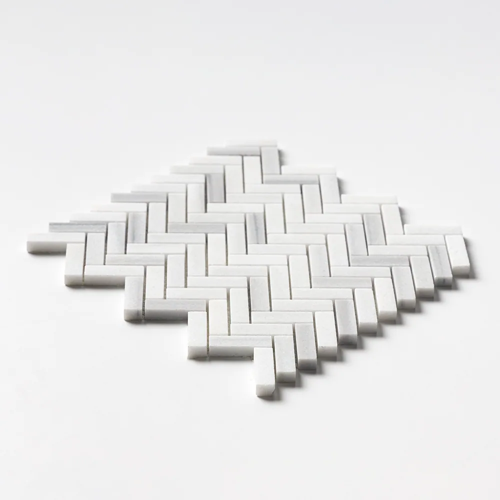 Bright white Frost White marble in a fine herringbone, the sheet angled low so the zig-zag edge reads clearly against white.