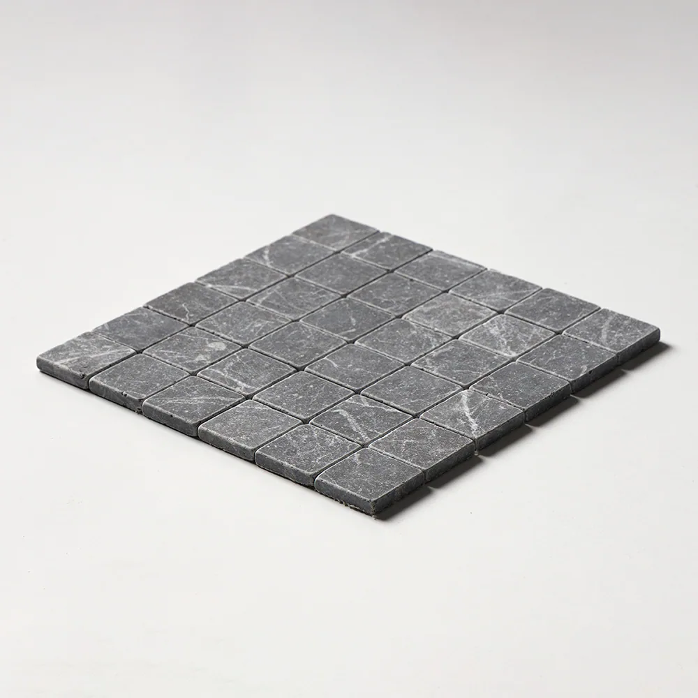 Iris Black mosaic of tumbled two-inch squares in dark charcoal marble, the sheet angled against a white ground.