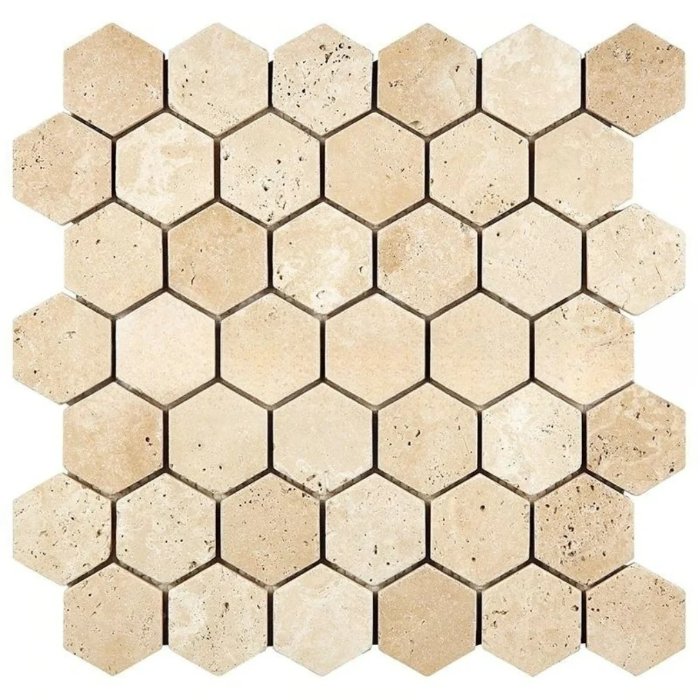 Tumbled Ivory travertine mosaic of 2 inch hexagons in warm beige, the softened edges and open natural pitting characteristic of unfilled travertine.