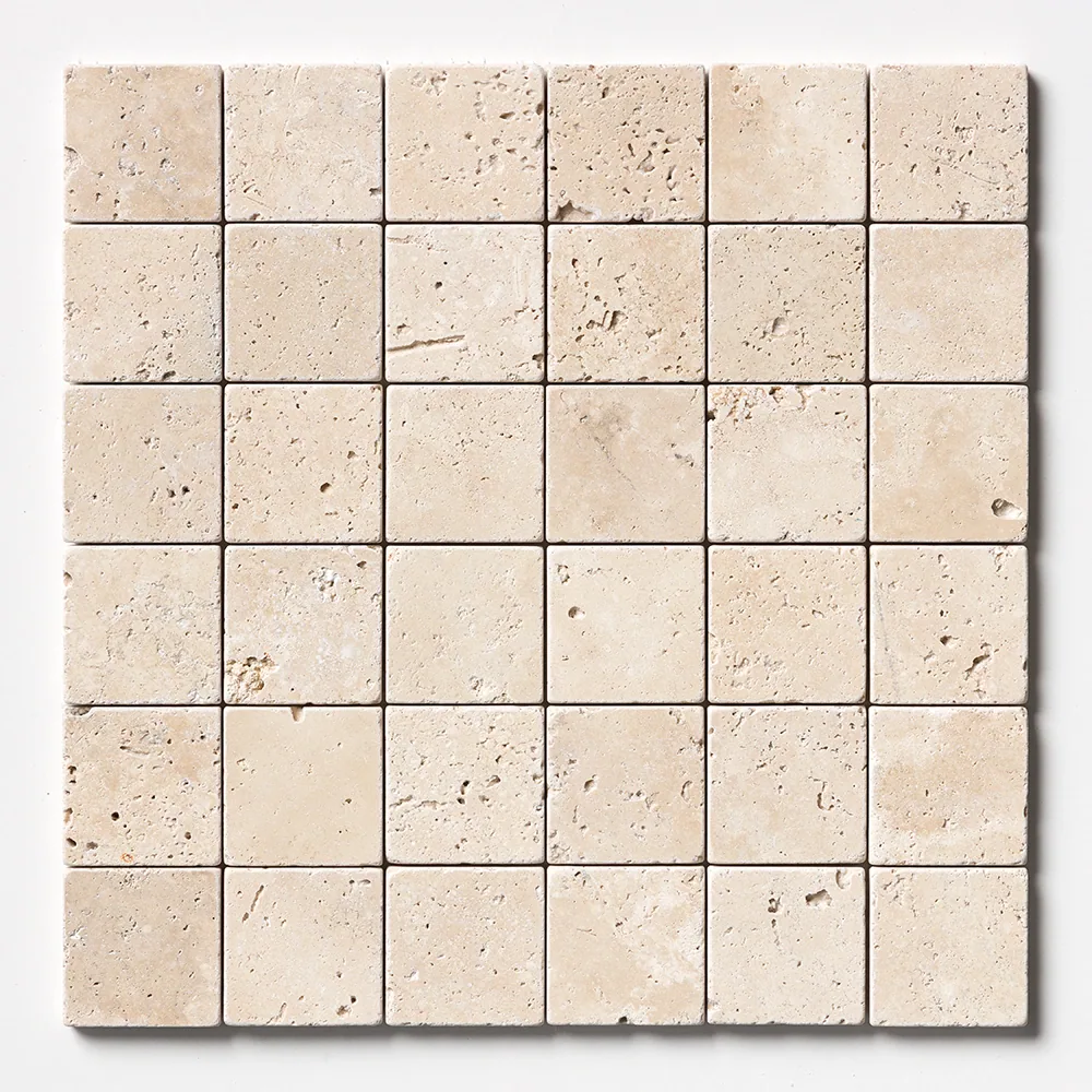 Thirty-six two-inch travertine squares straight on, varying from pale cream to light tan with heavy natural pitting across the faces.