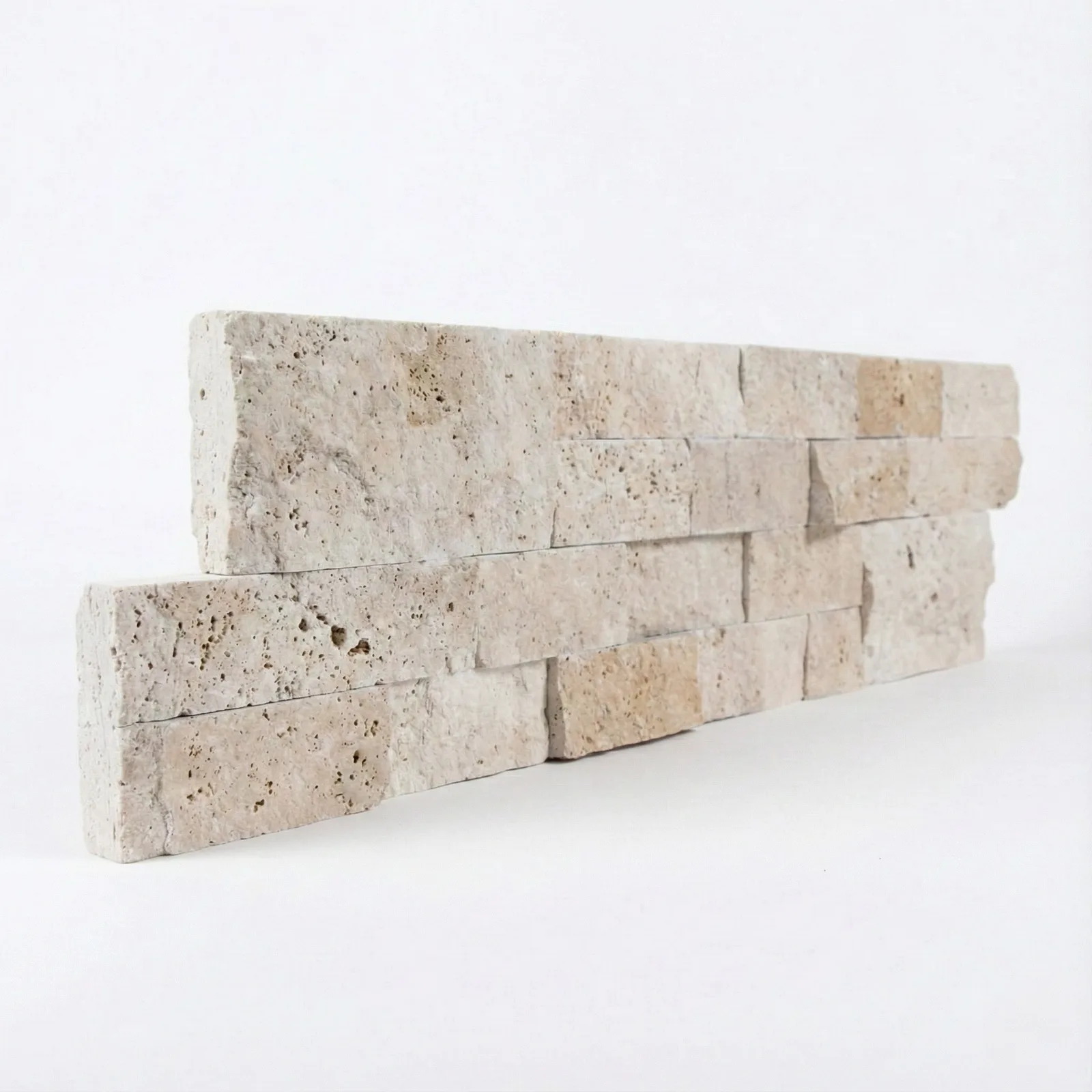 Light Travertine corner piece seen at an angle, showing how far the split faces project from the bed of the panel.