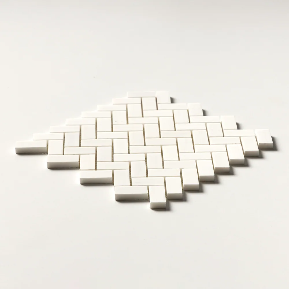 Snow White marble in a 1 by 2 inch herringbone, crisply white and angled so the stepped edge of the sheet is visible.