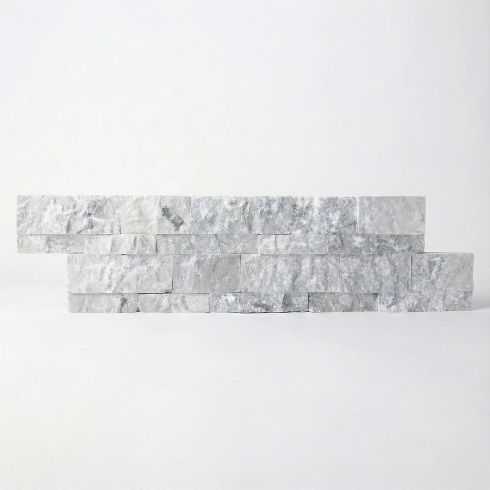 A Tundra Grey marble ledger panel corner piece, the returned end showing the panel's depth against a studio ground.