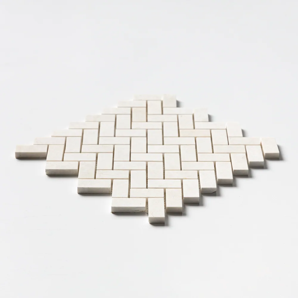 Vanilla marble in a 1 by 2 inch herringbone, warm off-white and matt, the sheet angled on a white ground.