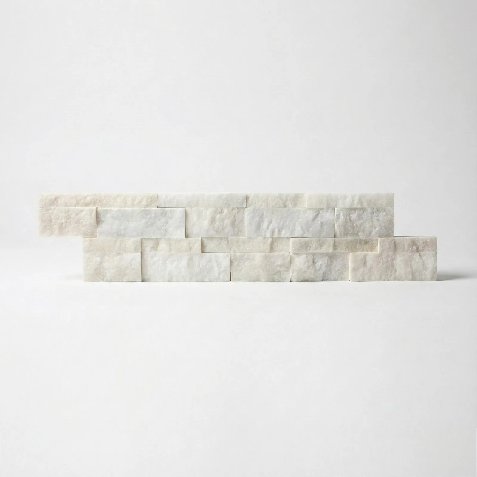 A single white marble ledger panel photographed straight on, showing the cream and chalk banding across its split face.