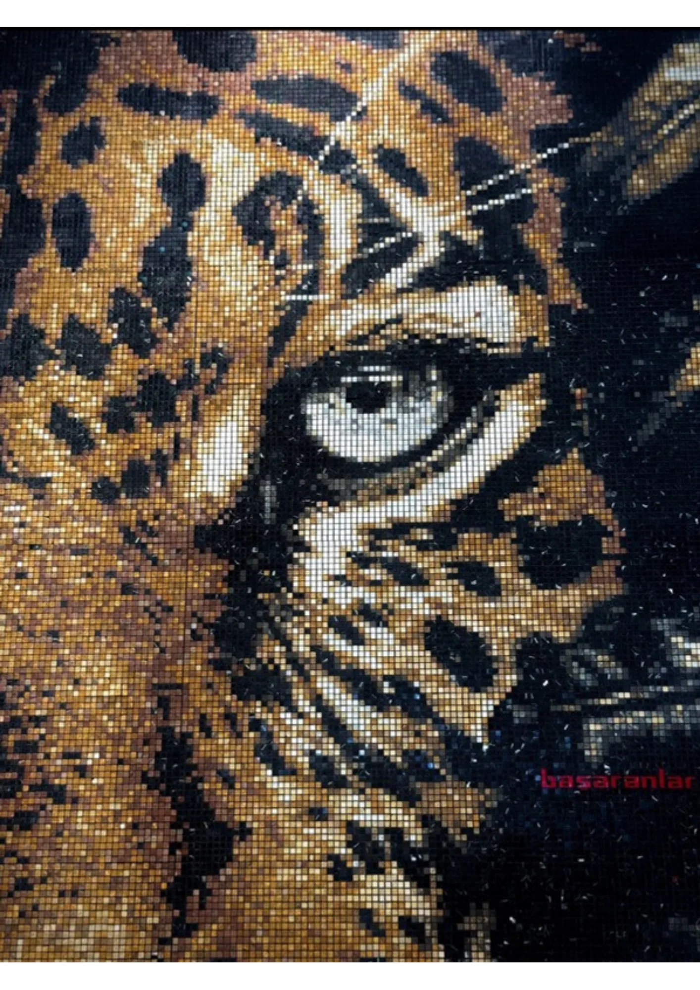 Close photograph of a finished mosaic: the leopard's eye and cheek in real stone and glass, individual tesserae throwing scattered specular glints at different angles, the physical relief of each piece visible at the grout lines.